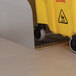 A yellow bucket with wheels sits on a metal floor.