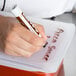 A hand writing "Flexsil Lid 1/4 Size" on a plastic container with a brown and white marker.