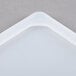 A white high-heat silicone lid for a steam table pan with a triangle shape.