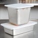 A white high-heat silicone lid on a metal food container.