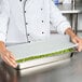 A chef holding a Flexsil lid over a container of peas.
