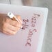 A hand writing "Flexsil Lid" on a plastic tray.