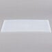 A white rectangular Flexsil lid on a gray surface.