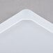 A white high-heat silicone lid with a corner of a white object.