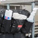 A black bag with a white towel and spray bottle inside.