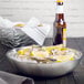 A bowl of oysters and lemons on an American Metalcraft stainless steel seafood tray.