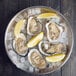 An American Metalcraft stainless steel seafood tray with oysters and lemon slices on ice.