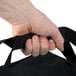 A hand holding a black Cres Cor insulated food delivery bag with a black strap.