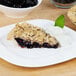 A close-up of a slice of Lucky Leaf blueberry pie on a plate.