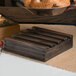 A wooden box on a table with a bowl of bagels inside.