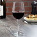 A Reserve by Libbey wine glass filled with red wine on a table.