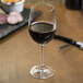 A Reserve by Libbey wine glass filled with red wine on a table.