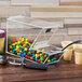 A Cal-Mil stackable topping dispenser filled with candy on a counter in an ice cream shop.