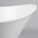 A close-up of a Libbey white porcelain bowl with a curved edge.