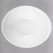 A Libbey aluma white porcelain infinity bowl with a curved edge.