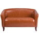 A brown leather Flash Furniture loveseat with wooden legs.