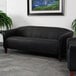 A Flash Furniture black leather sofa in a lounge area.