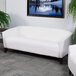 A white Flash Furniture Hercules Imperial leather sofa with wooden feet in a room.