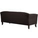 A Flash Furniture black leather sofa with wooden legs.