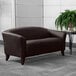 A brown leather Flash Furniture Hercules loveseat in a room with a potted plant.