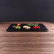 a black plate with vegetables on it