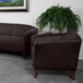 A brown leather Flash Furniture chair with wooden feet in a lounge area.