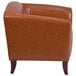 A Flash Furniture brown leather chair with wooden legs.