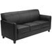 A black leather couch with a wooden leg.