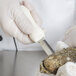 A person in white gloves using a Dexter Russell Providence style oyster knife to cut an oyster.