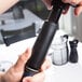 A hand using the Vacu Vin wine saver to pump air out of a bottle of wine.