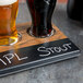 A Cal-Mil faux wood tray with two glasses of beer on it.