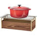 A red pot with a lid on a walnut and brass Cal-Mil chafer alternative rack.