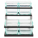 A black metal rack holding three square glass containers with black lids.