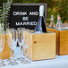 A Cal-Mil Madera rustic pine ice housing with wine and champagne on a table.