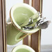 A metal Cal-Mil vertical flatware holder with spoons inside.