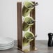 A wooden Cal-Mil utensil holder with three cups and utensils.