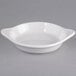 A Tuxton white china shirred egg dish with a handle.