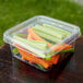 A Fabri-Kal Greenware plastic deli container filled with carrots and celery.
