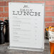 A clear Cal-Mil card holder with a menu on a table.