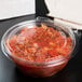 a plastic container of salsa