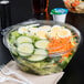A salad in a Dart plastic bowl with a fork.