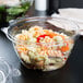 A close-up of a Dart clear plastic bowl with pasta inside.