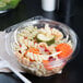 A Dart plastic bowl with pasta and vegetables with a clear lid.