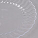 A clear plastic Fineline Flairware plate with wavy edges.