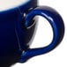 A close-up of a blue Tuxton cappuccino cup with a handle.