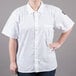 A woman wearing a white Chef Revival short sleeve cook shirt.