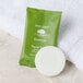 A white Basic Earth Botanicals facial soap bar in green packaging with white text.