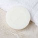 A Basic Earth Botanicals white facial soap bar wrapped in white paper.