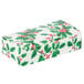 A white candy box with green holly leaves and red berries.