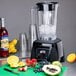 A Waring commercial blender with fruit on a cutting board.